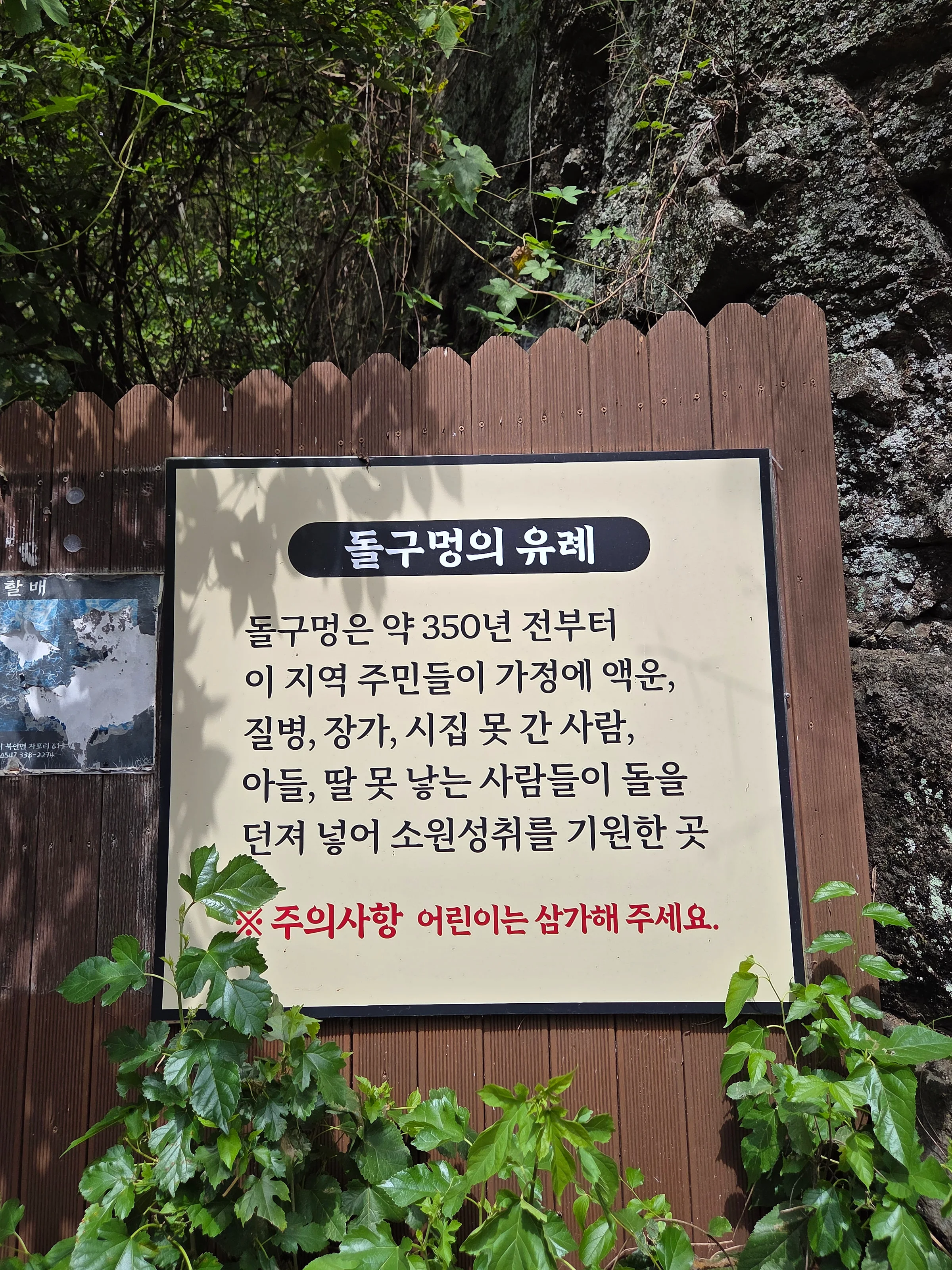 돌구멍 유례 안내판. 약 350년 전부터 주민들이 액운을 물리치고 소원을 빌며 돌을 던져 넣던 곳이라는 설명이 적혀 있다.