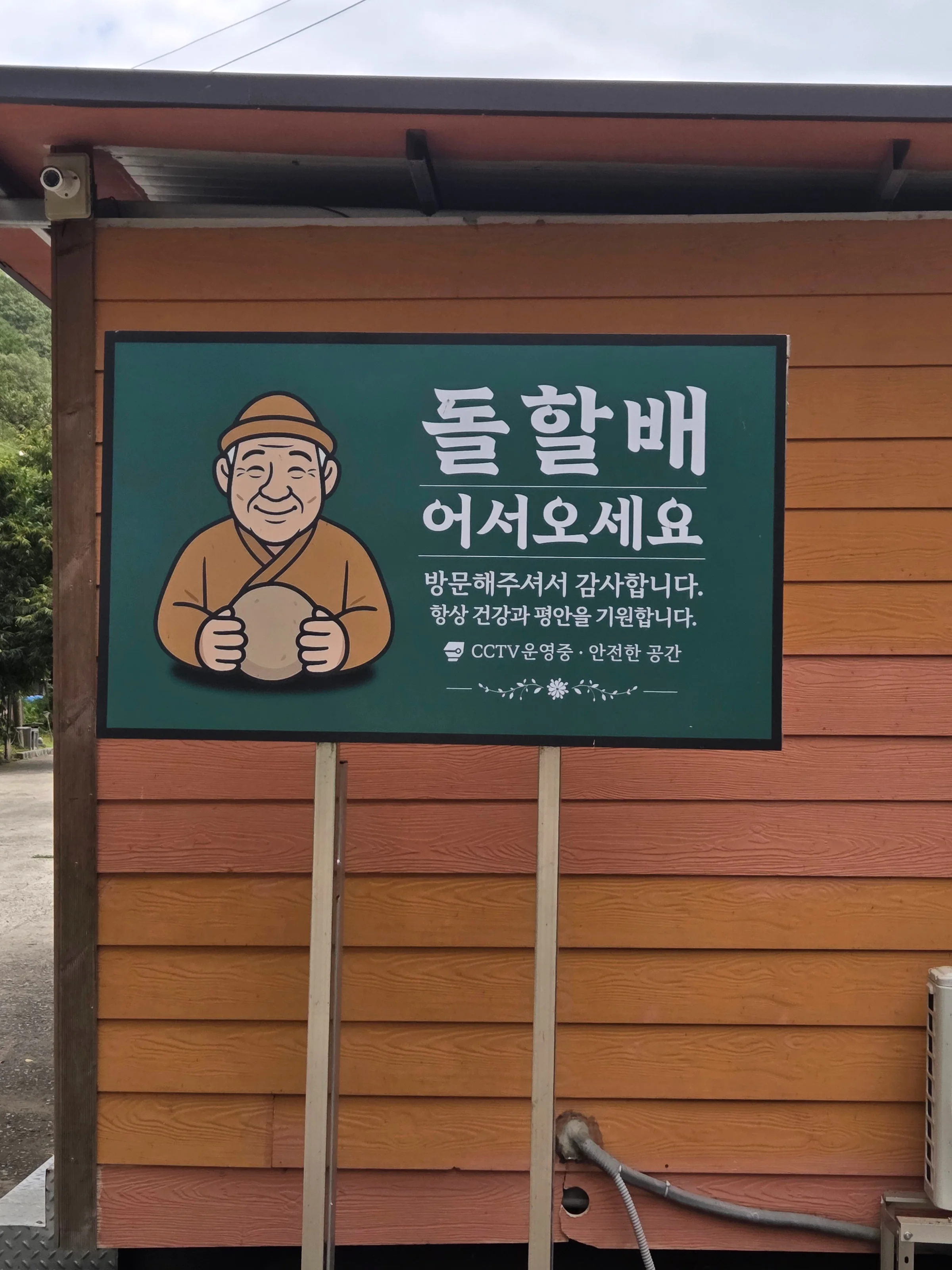 '돌할배 어서오세요' 캐릭터 안내판이 걸린 입구 관리동.